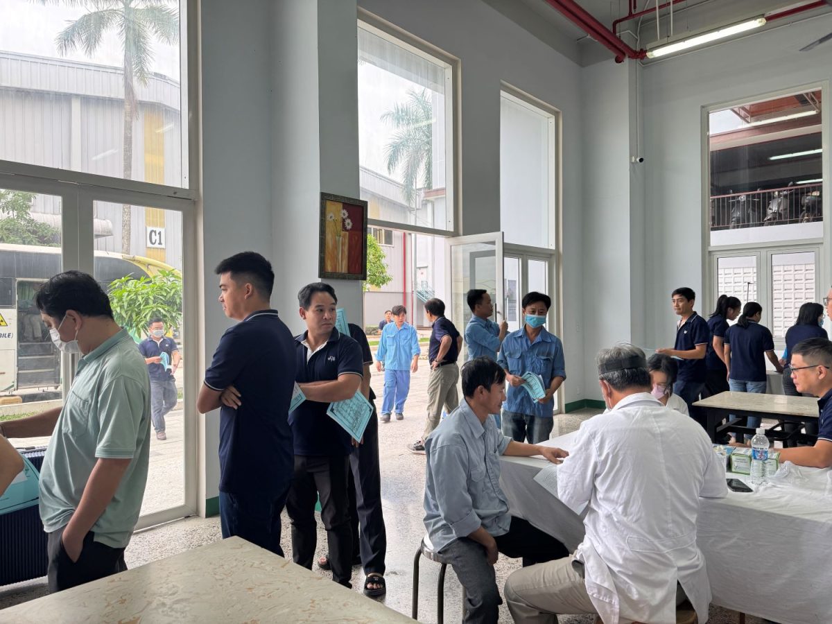 Người lao động xếp hàng chờ khám lâm sàng bên cạnh khu vực xe y tế lưu động.