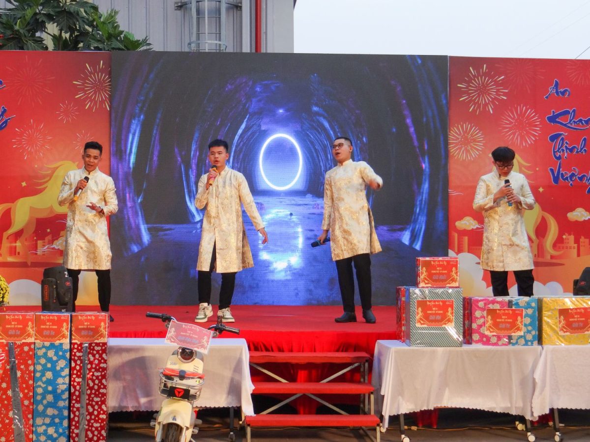 Tiết mục văn nghệ cây nhà lá vườn sôi động của các nam nhân viên trong trang phục áo dài Tết.