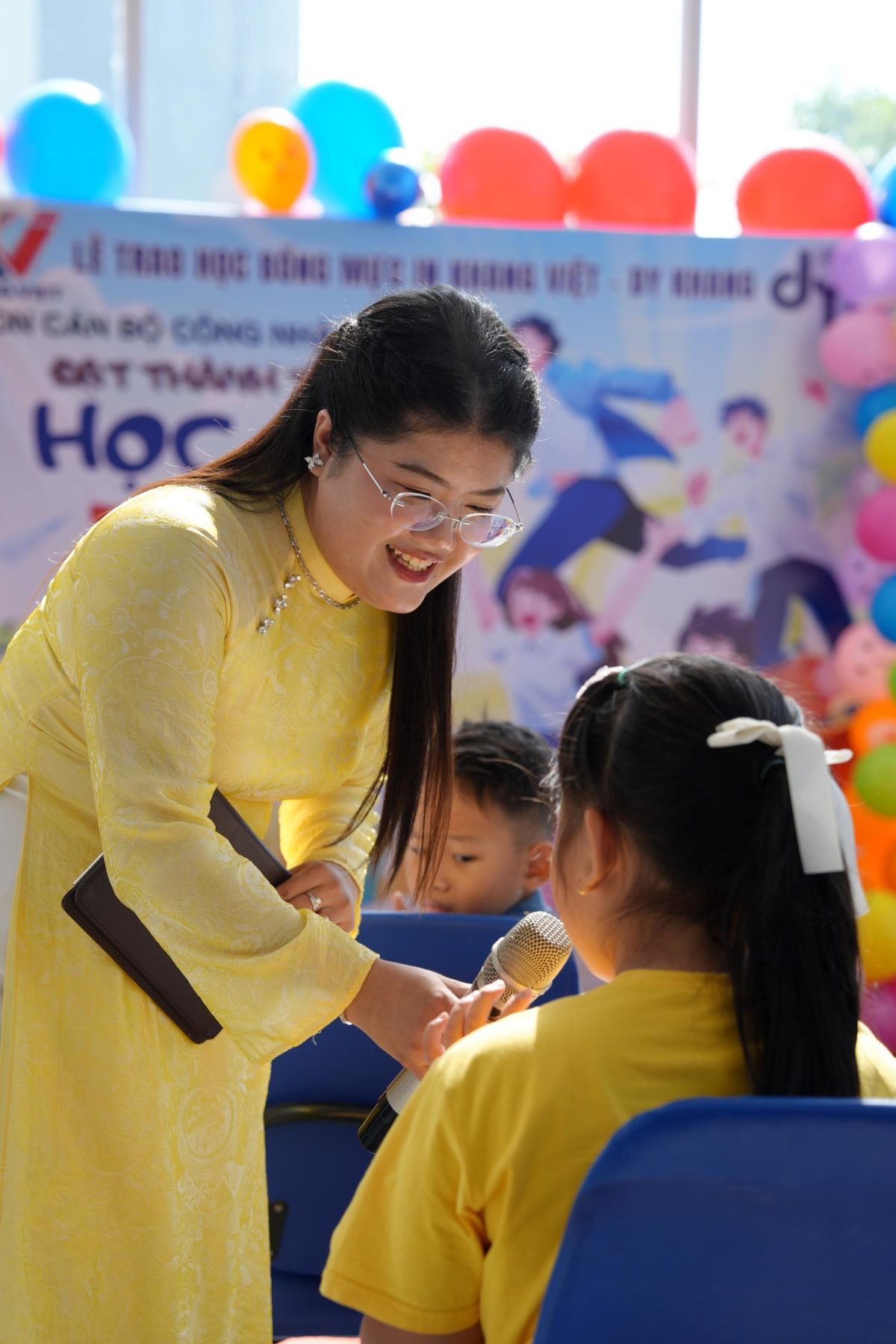 MC giao lưu và trao micro cho học sinh phát biểu cảm nghĩ tại buổi lễ.